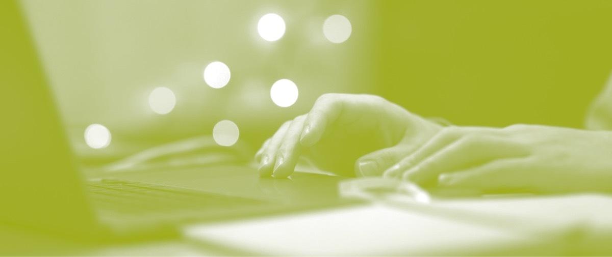 Green-tinted photo of hands on a keyboard