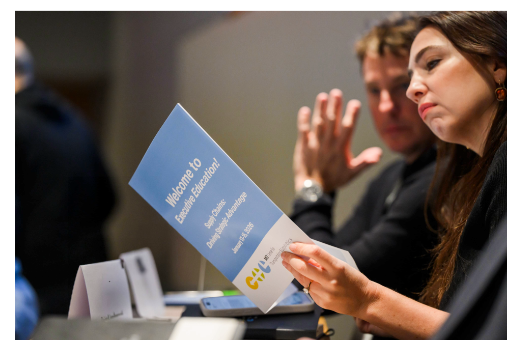 Two people at Exec Ed - one looking at brochure and other looking over