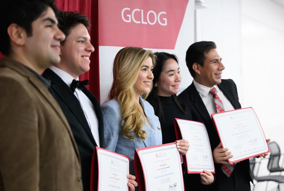 Four students holding their GCLOG certificates - side angle