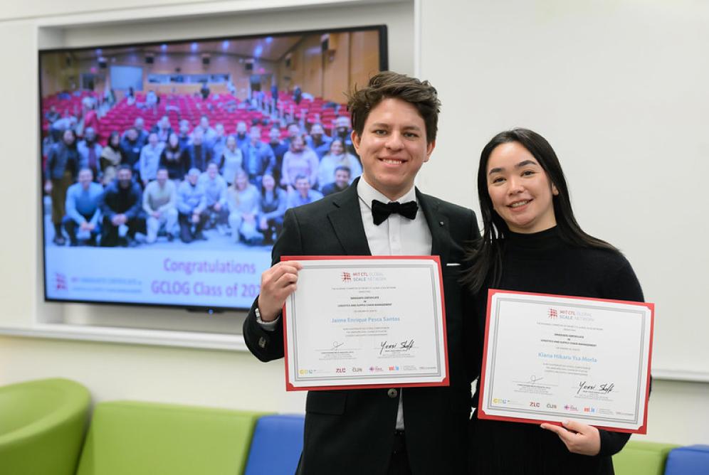 Two students holding certificates 