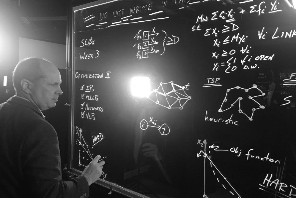 Caplice writing formulas on a whiteboard