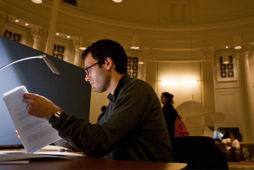 MIT student studying at a library desk
