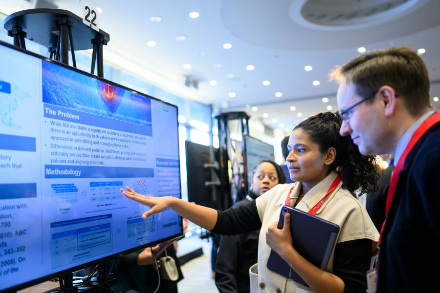 Woman presenting project on screen to onlooker
