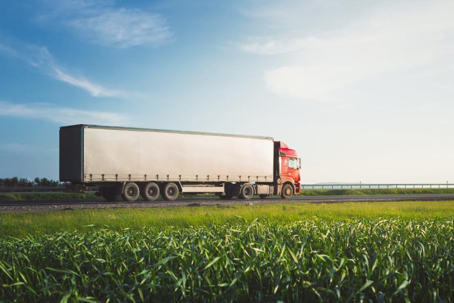 semi truck driving through a cornfield