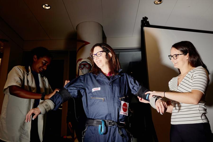 MIT AgeLab researchers Sophia Ashebir, left, and Taylor Brennan outfit Amy Dockser Marcus with the age-simulation suit.